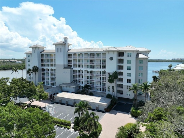view of property featuring a water view and uncovered parking