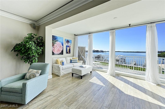 living room featuring a wall of windows, wood finished floors, crown molding, and a water view