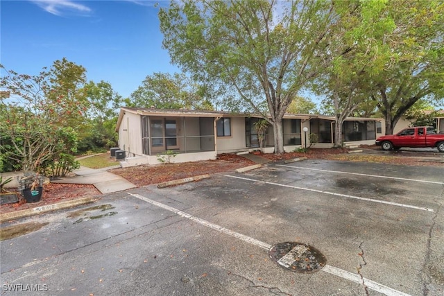 ranch-style home with uncovered parking and a sunroom