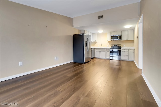 kitchen featuring visible vents, dark wood-style floors, appliances with stainless steel finishes, light countertops, and white cabinetry