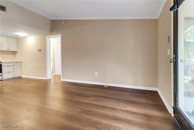 unfurnished living room with lofted ceiling, wood finished floors, visible vents, baseboards, and ornamental molding