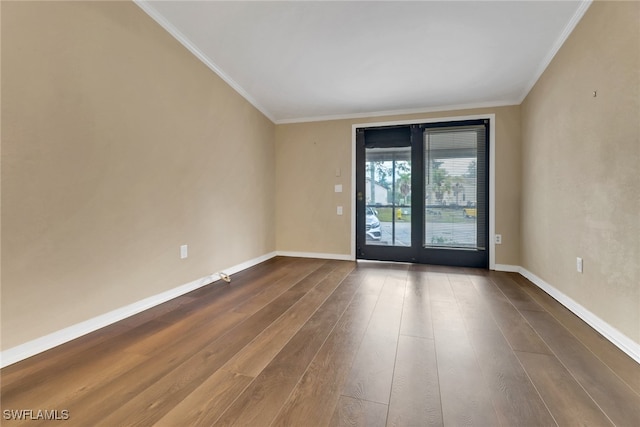 spare room featuring ornamental molding, wood finished floors, and baseboards