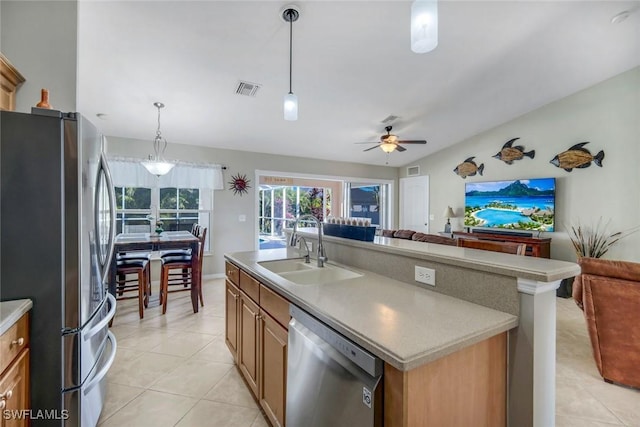 kitchen featuring visible vents, open floor plan, hanging light fixtures, stainless steel appliances, and a sink