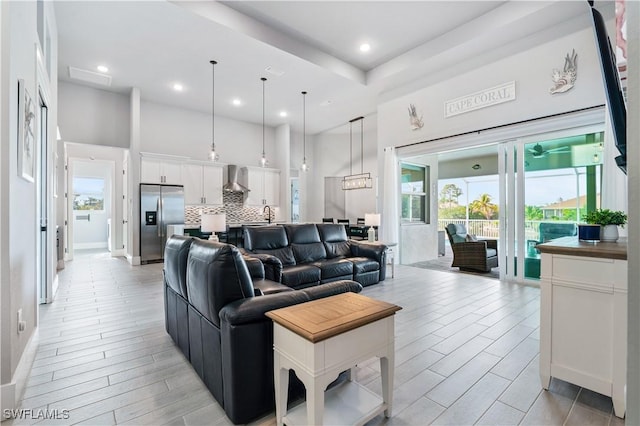 living area with recessed lighting, a towering ceiling, and wood tiled floor