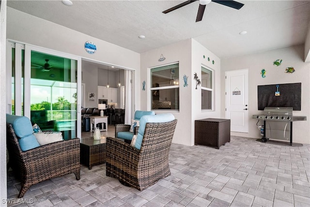 view of patio / terrace featuring a ceiling fan, an outdoor living space, and area for grilling