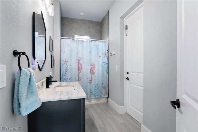 bathroom with wood tiled floor, baseboards, and vanity