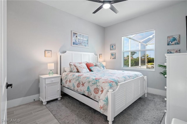 bedroom with light wood-style floors, ceiling fan, and baseboards