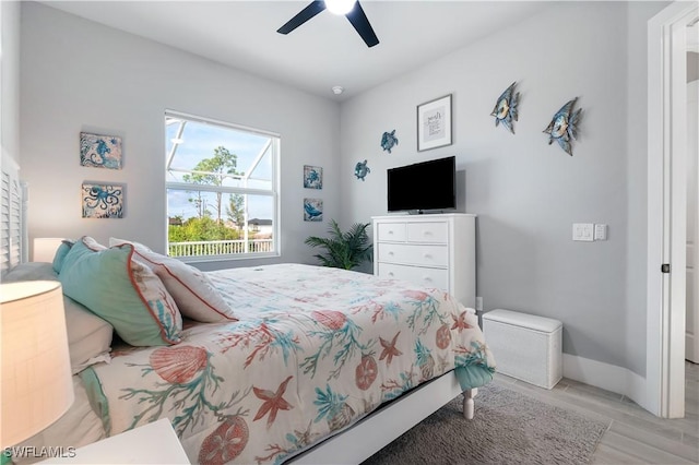 bedroom with ceiling fan, baseboards, and light wood-style flooring