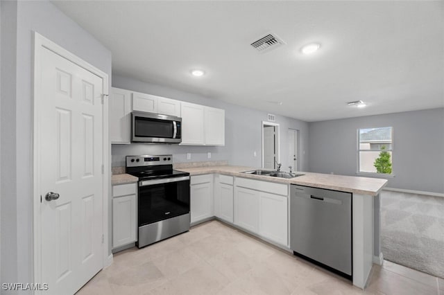 kitchen featuring visible vents, light countertops, appliances with stainless steel finishes, white cabinetry, and a peninsula