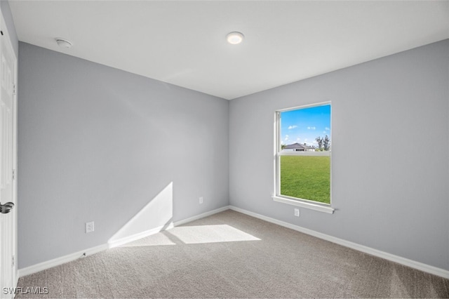 carpeted spare room with baseboards