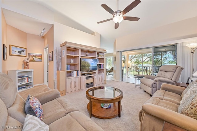 carpeted living room with ceiling fan and high vaulted ceiling