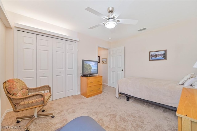 bedroom with ceiling fan, visible vents, a closet, and light colored carpet