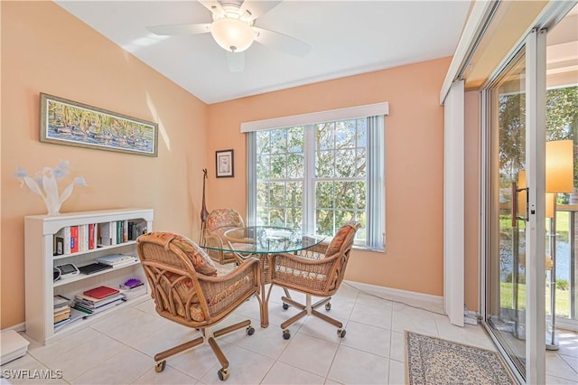 dining space with ceiling fan, light tile patterned flooring, and baseboards