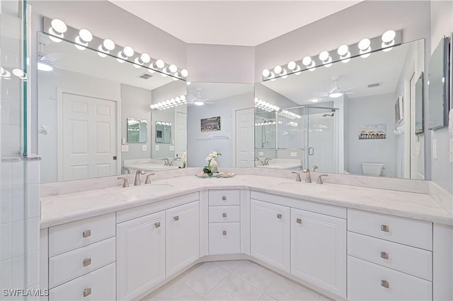 full bathroom featuring a stall shower, ceiling fan, tile patterned flooring, and a sink