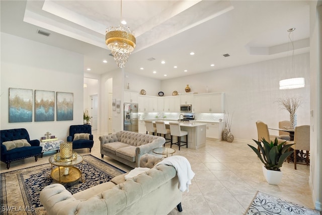 living room featuring a chandelier, light tile patterned flooring, recessed lighting, visible vents, and a raised ceiling