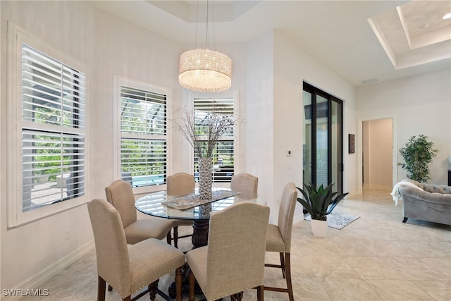 dining space with a tray ceiling, a high ceiling, and baseboards