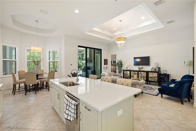 kitchen with an inviting chandelier, visible vents, a tray ceiling, and a sink