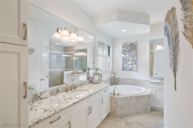 bathroom with a bath, a stall shower, two vanities, and a sink