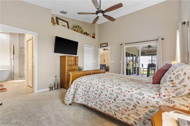 carpeted bedroom featuring visible vents, ceiling fan, ensuite bathroom, access to outside, and a high ceiling