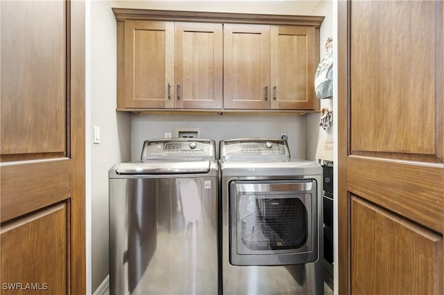 washroom featuring cabinet space and separate washer and dryer