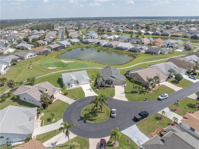 drone / aerial view with a water view, view of golf course, and a residential view