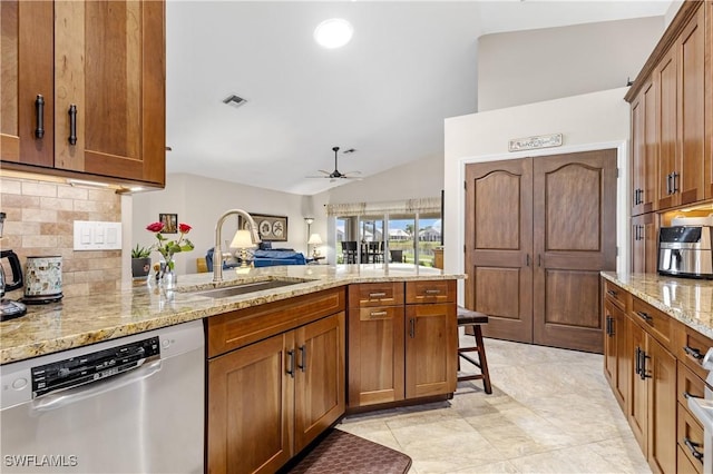 kitchen with a peninsula, a sink, backsplash, brown cabinets, and dishwasher