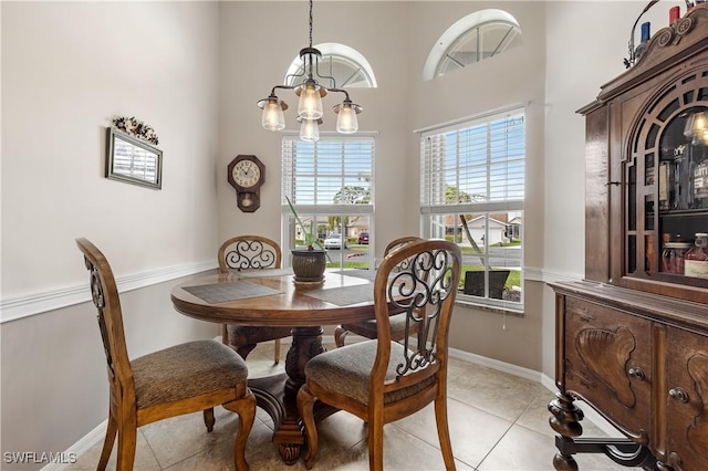 dining space with baseboards, an inviting chandelier, and light tile patterned floors