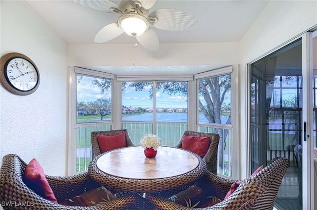 sunroom with a water view and a ceiling fan