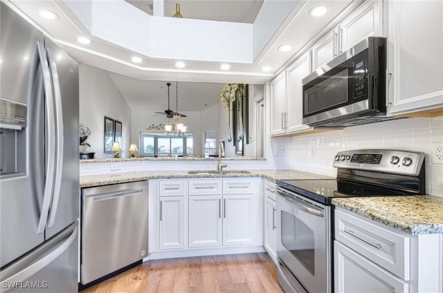 28068 Cavendish Ct Unit 2308, Bonita Springs, FL 34135 - kitchen with appliances with stainless steel finishes, recessed lighting, white cabinetry, light wood finished floors, and backsplash