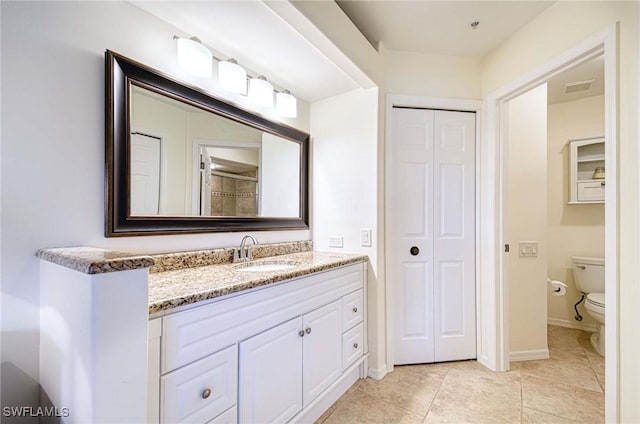 full bathroom with baseboards, visible vents, toilet, vanity, and a closet