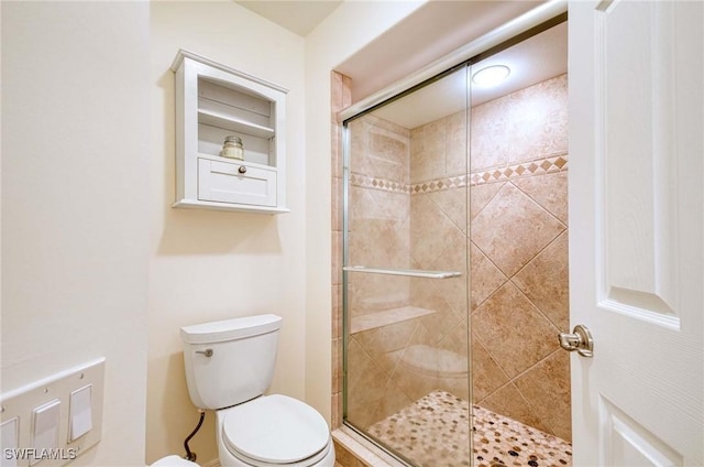 bathroom with a shower stall and toilet