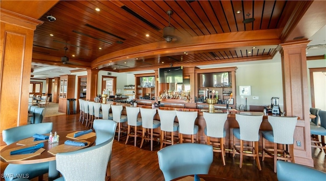 bar featuring wood ceiling, beam ceiling, wood finished floors, and decorative columns