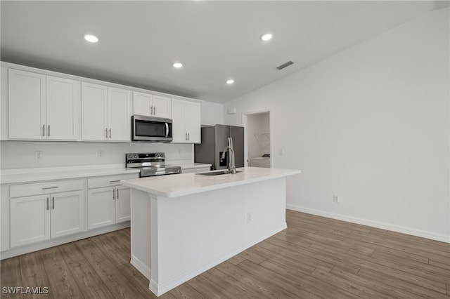 kitchen featuring light wood finished floors, an island with sink, appliances with stainless steel finishes, white cabinetry, and a sink