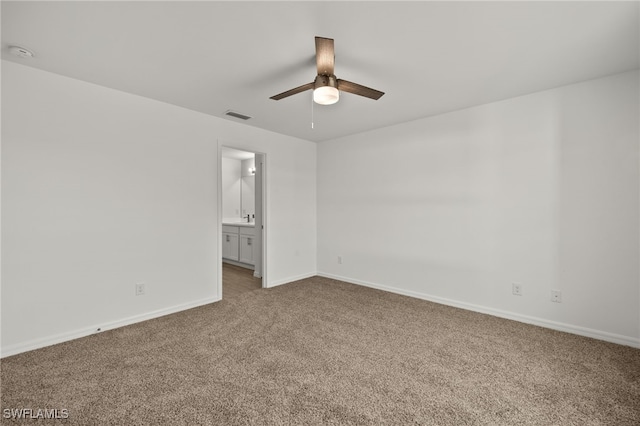 unfurnished bedroom featuring baseboards, visible vents, ceiling fan, ensuite bathroom, and carpet flooring