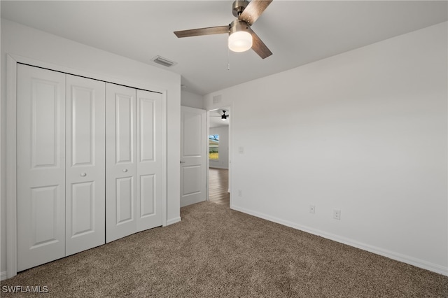 unfurnished bedroom featuring a closet, visible vents, a ceiling fan, carpet flooring, and baseboards