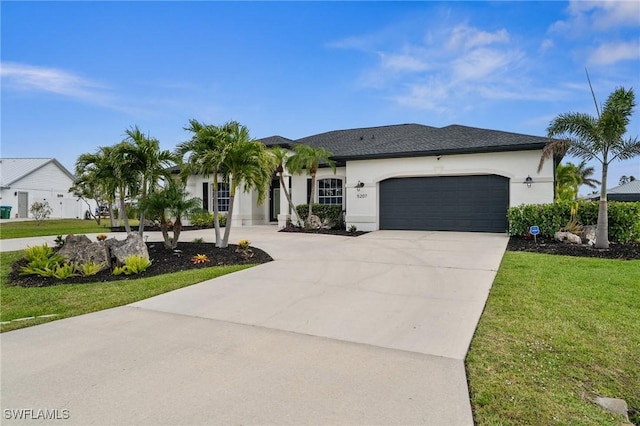 view of front of house featuring a front yard, concrete driveway, an attached garage, and stucco siding