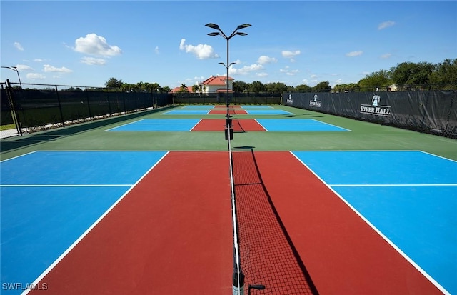 view of tennis court featuring community basketball court and fence