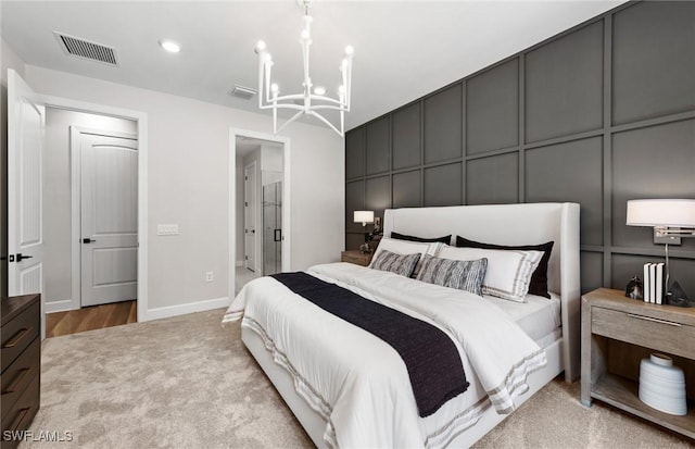 bedroom featuring light carpet, a notable chandelier, visible vents, and a decorative wall