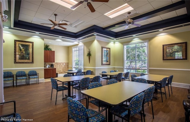 dining space with dark wood-style floors, a tray ceiling, and baseboards