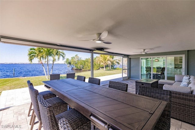 view of patio / terrace featuring a water view, outdoor dining area, a ceiling fan, and outdoor lounge area