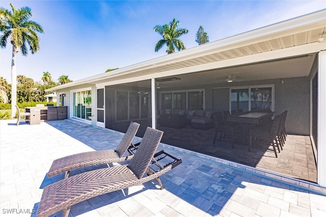 view of patio with a sunroom, ceiling fan, and outdoor dining area