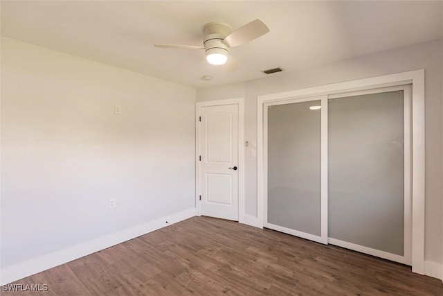 unfurnished bedroom with visible vents, baseboards, ceiling fan, dark wood-type flooring, and a closet