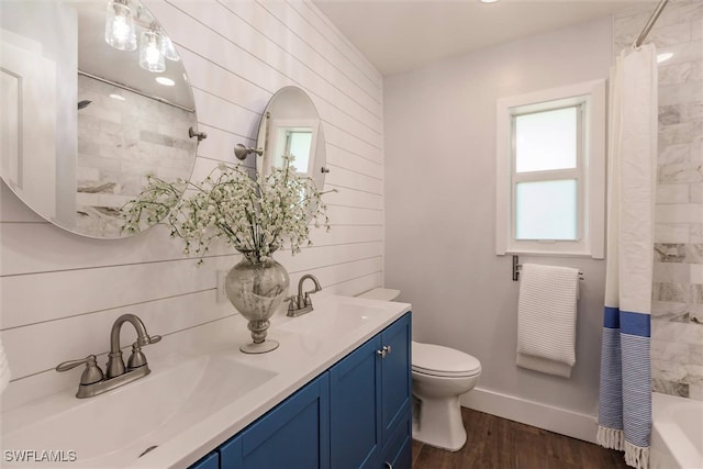 bathroom with wood finished floors, a sink, toilet, and shower / tub combo