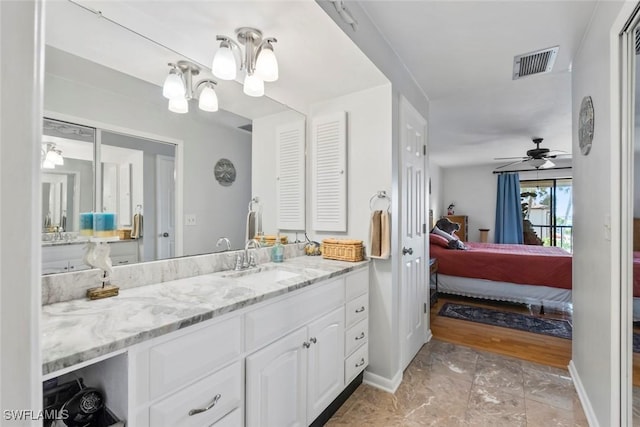 ensuite bathroom featuring visible vents, baseboards, ensuite bathroom, vanity, and ceiling fan with notable chandelier