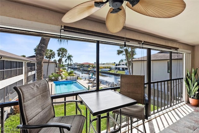 balcony with a water view and a ceiling fan