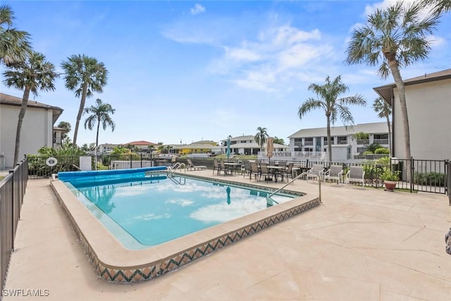 view of swimming pool featuring fence and a patio