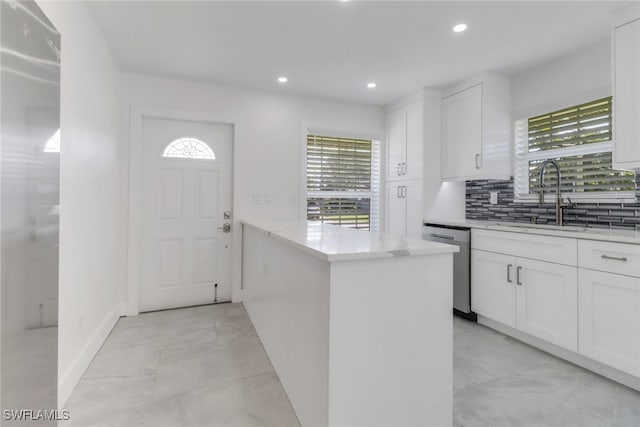 kitchen featuring a sink, marble finish floor, white cabinets, and dishwasher