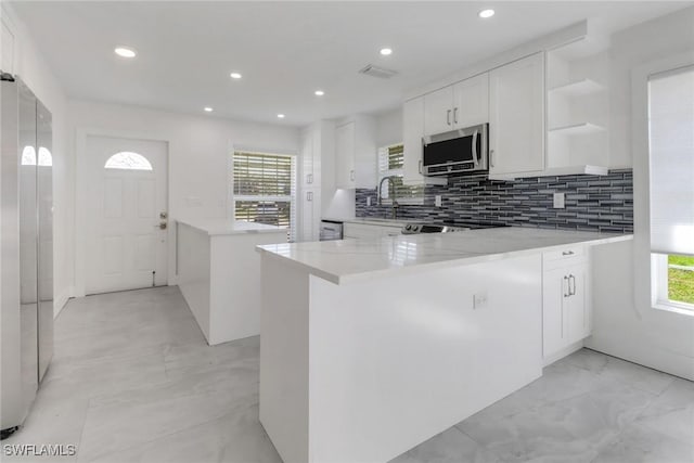 kitchen featuring stainless steel appliances, marble finish floor, a peninsula, and open shelves