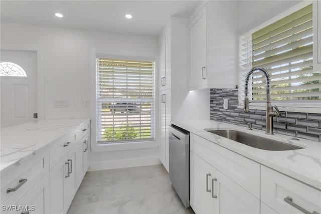 kitchen with tasteful backsplash, recessed lighting, stainless steel dishwasher, white cabinets, and a sink