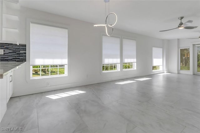 unfurnished dining area with a healthy amount of sunlight and ceiling fan